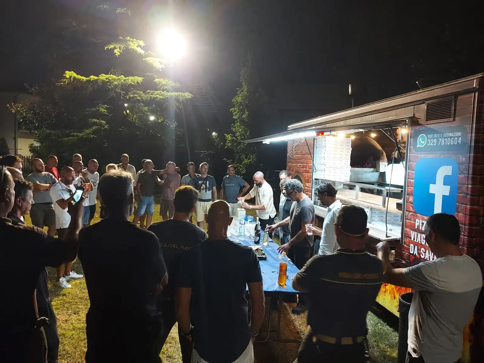 Il camion di sera, con le persone in fila davanti al banco