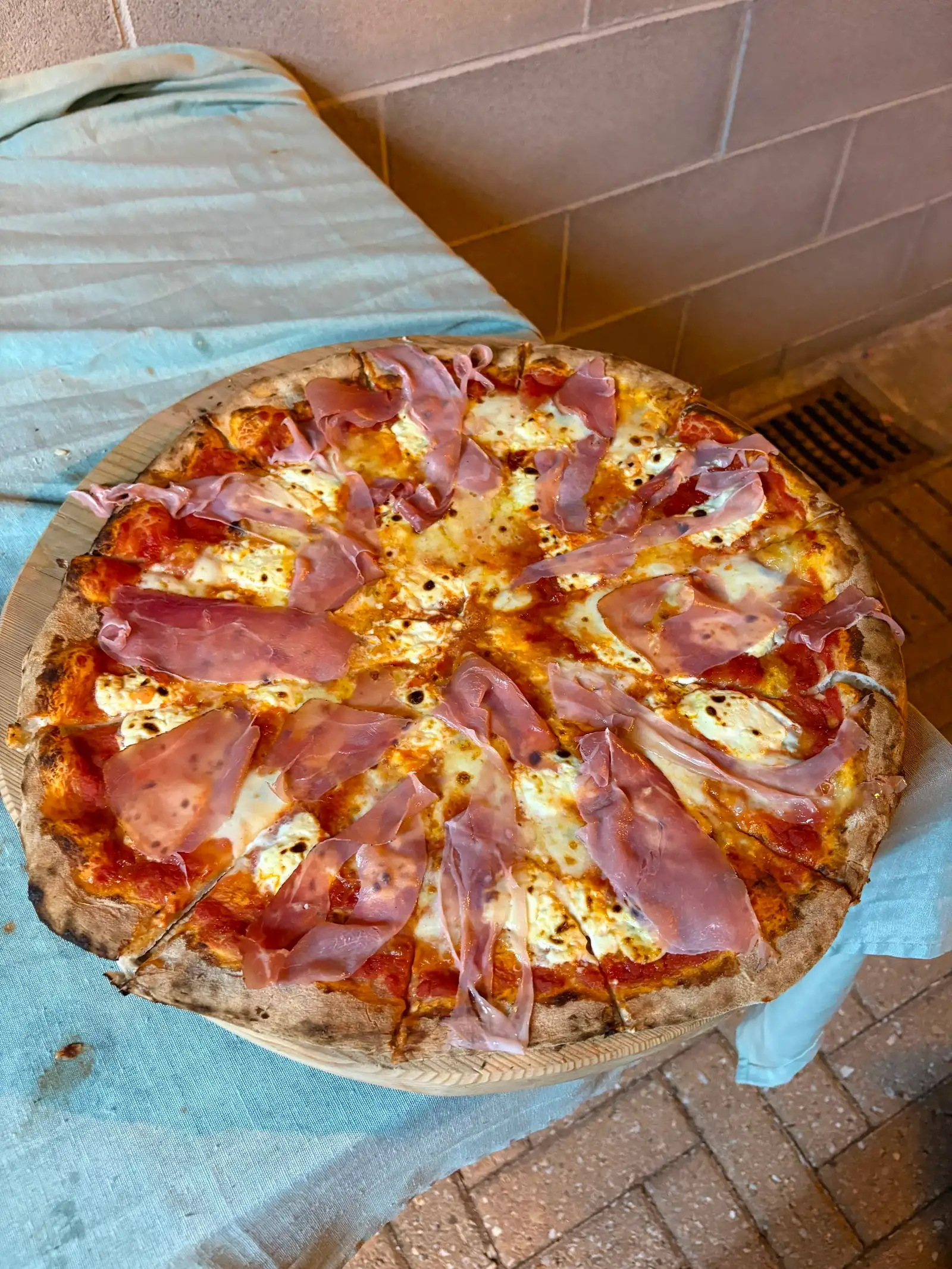 Una pizza al prosciutto appena uscita dal forno