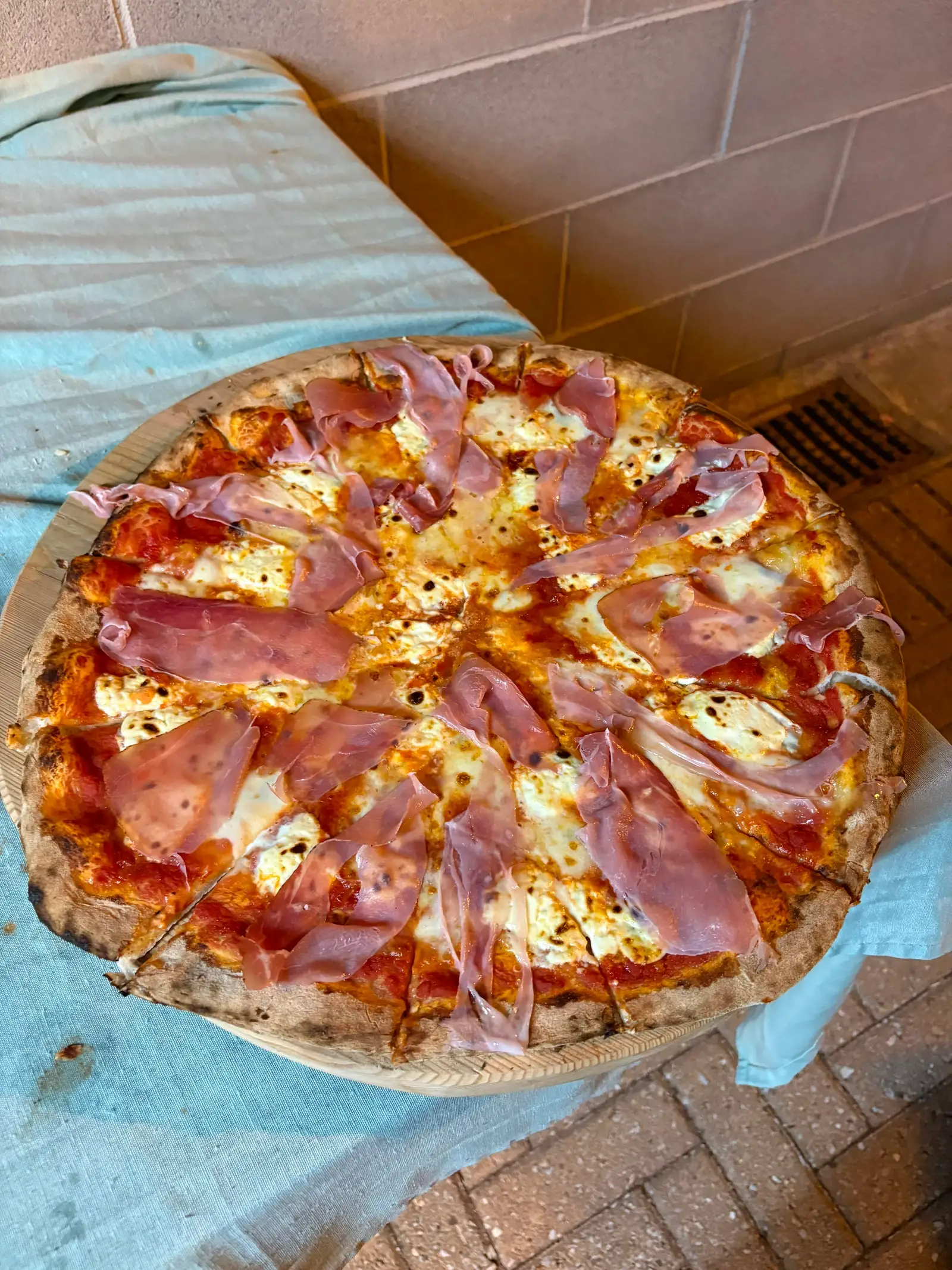 Una pizza al prosciutto appena uscita dal forno