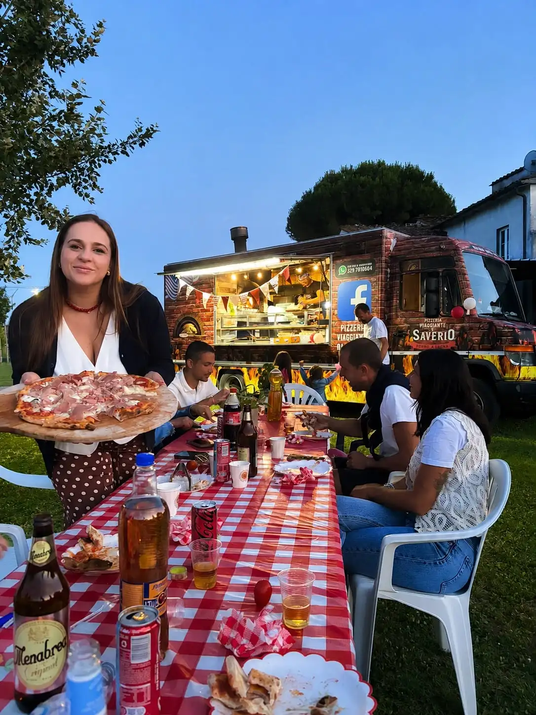 Una pizza servita a tavola, su una tovaglia a quadri rossi