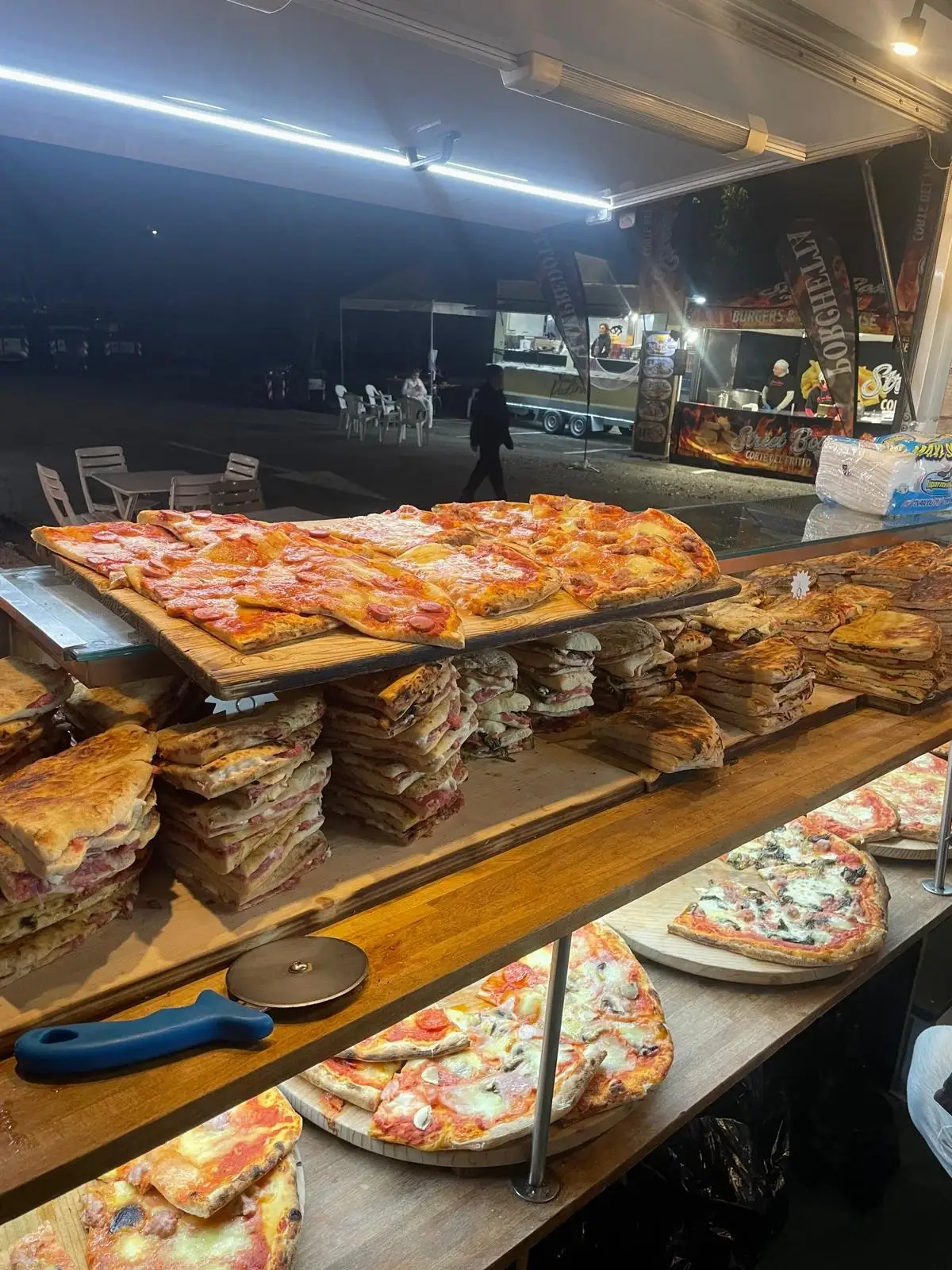 Il banco carico di pizze e schiacciate, di sera