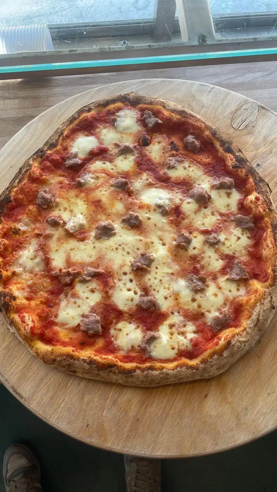 Una pizza appena sfornata sul tagliere, vista dall’alto