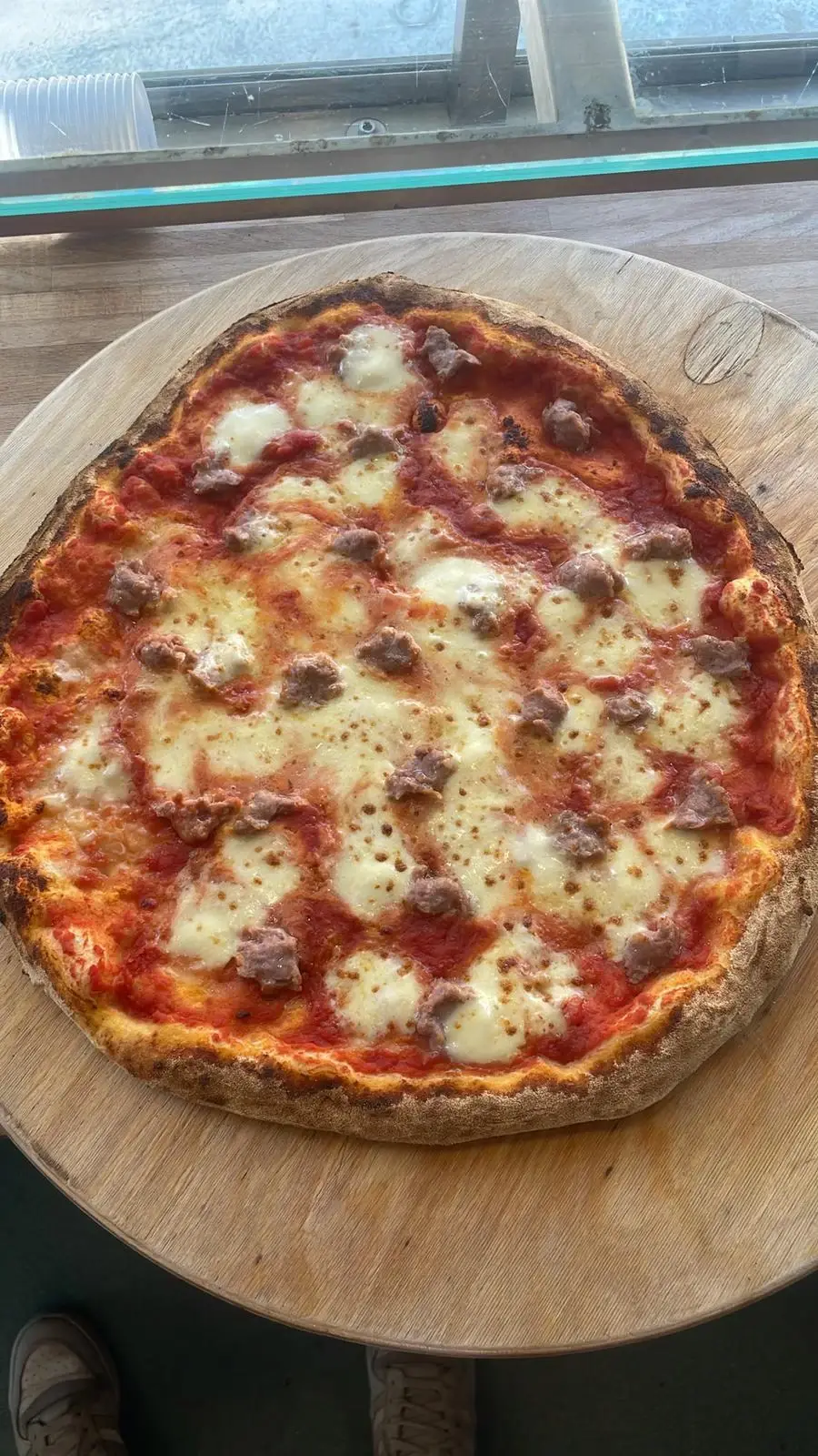 Una pizza appena sfornata sul tagliere, vista dall’alto