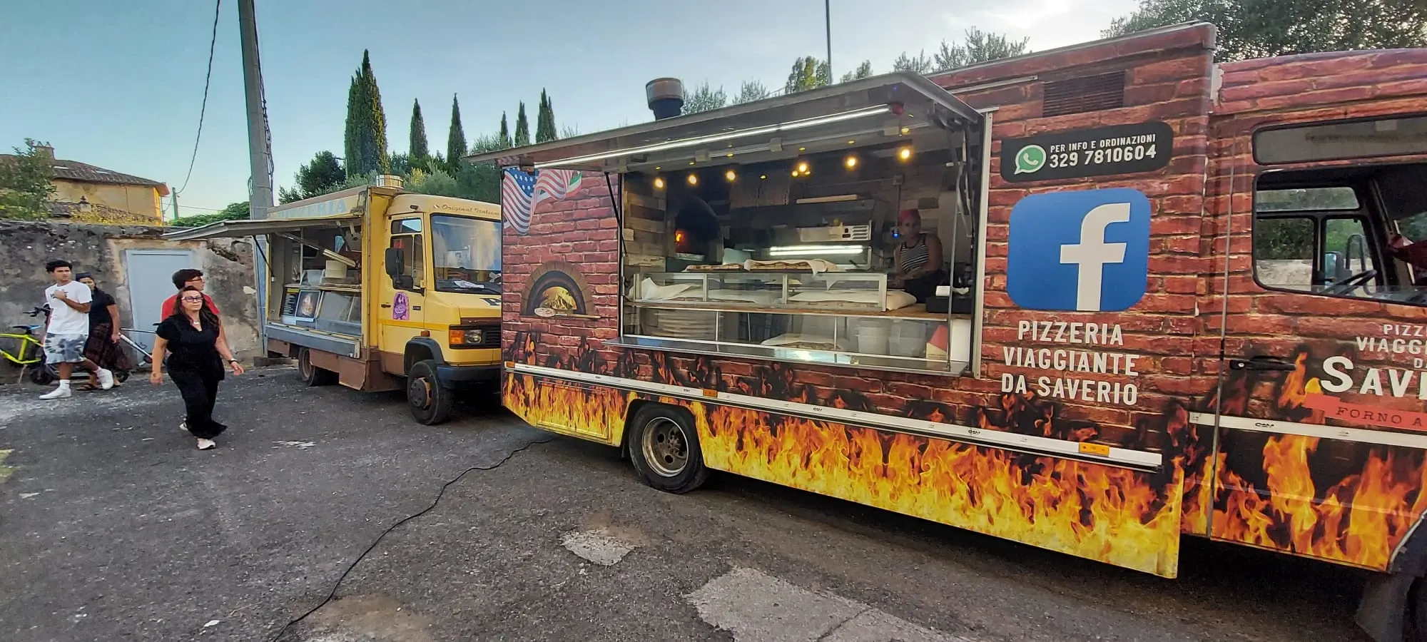 Il primo camion giallo e quello attuale, affiancati, con il banco aperto e il forno acceso