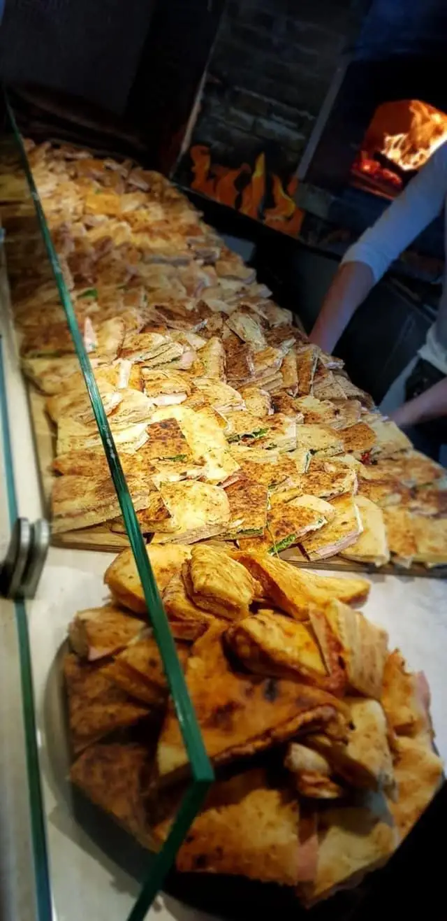 Schiacciate e calzoni sul banco, davanti al forno