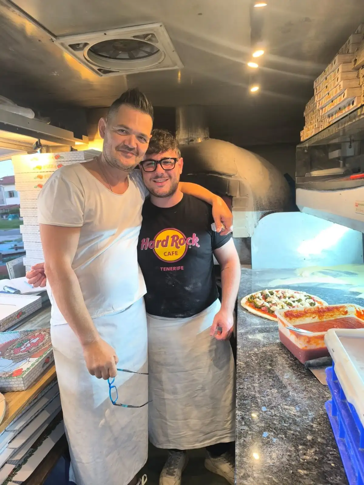 Due pizzaioli dentro il camion, davanti al forno
