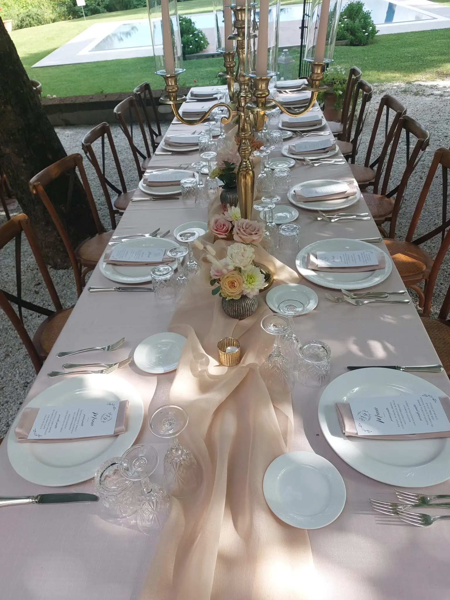 Tavolo apparecchiato per un matrimonio, con candelabri e fiori