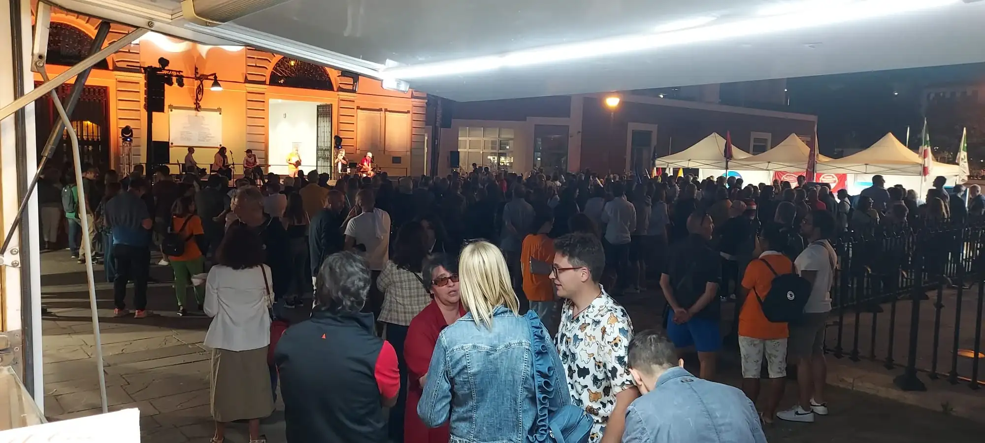 La folla in piazza, di sera, davanti ai banchi