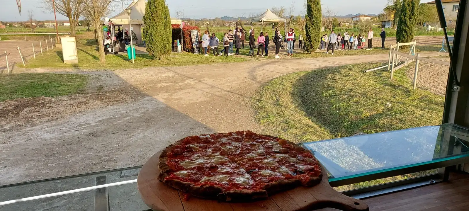 Una pizza sulla pala, con la campagna sullo sfondo