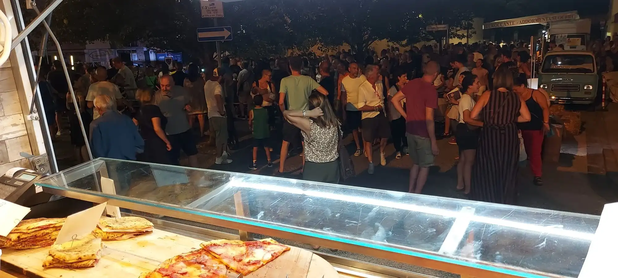 La folla davanti al banco illuminato, di sera